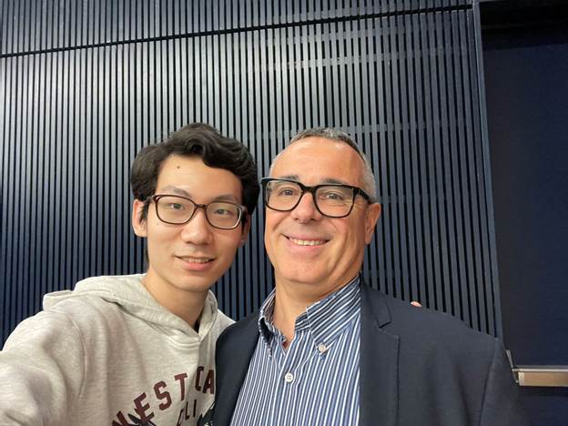 Two men taking a selfieDescription automatically generated with medium confidence